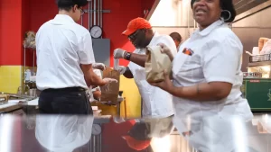 A deli worker preparing food, symbolizing workforce reintegration in addiction recovery.