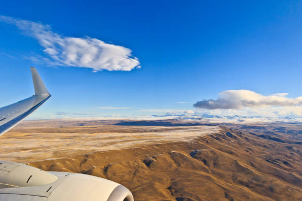 A commercial airplane flying over desert terrain between California and Arizona