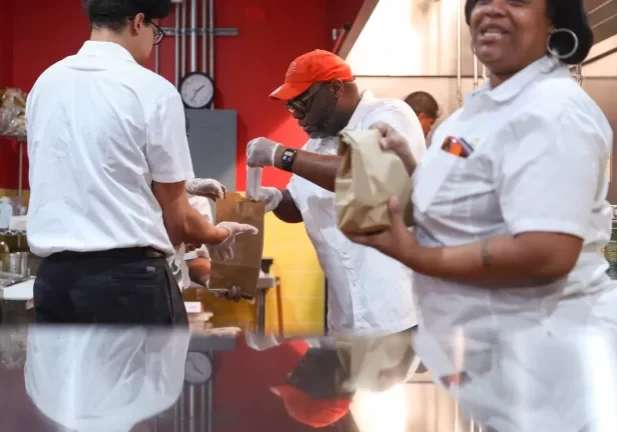 A deli worker preparing food, symbolizing workforce reintegration in addiction recovery.